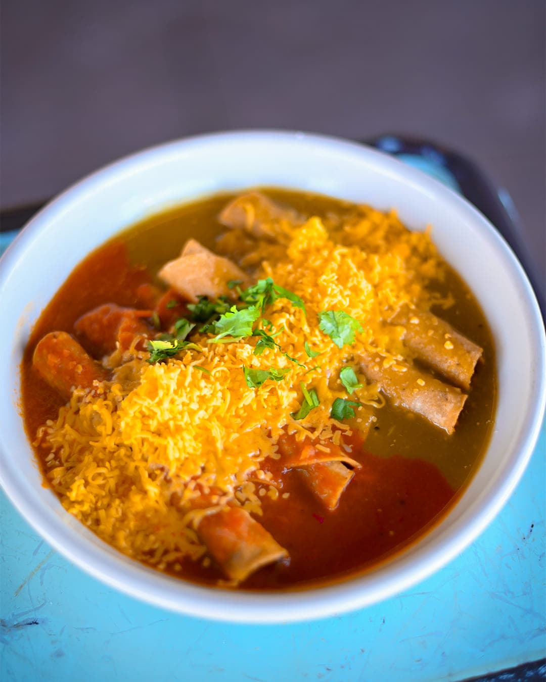 Bowl of enchiladas in red sauce topped with cheese and cilantro at Cabo Joe's