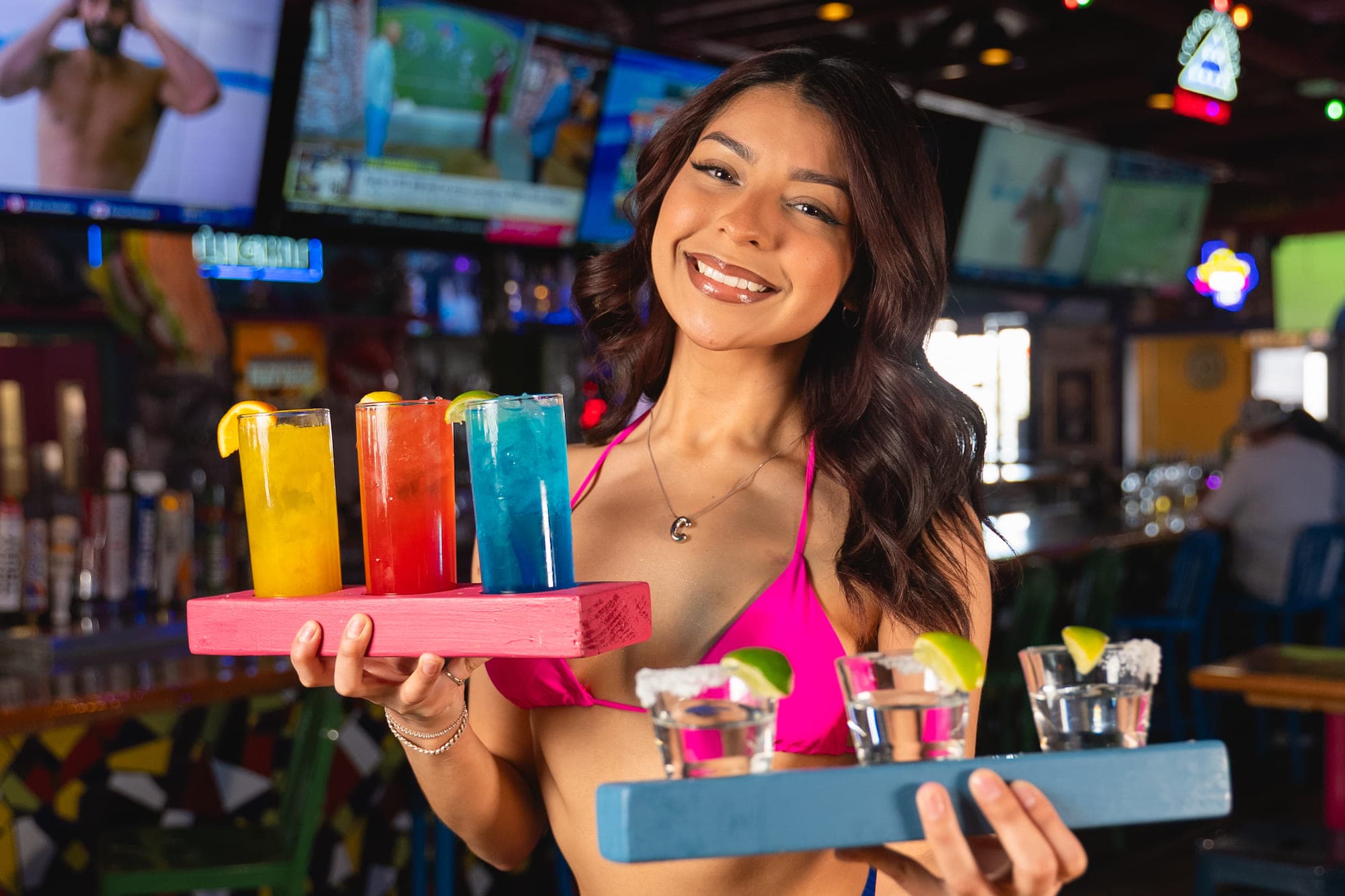 Cabo Joe's bartender holding a tray of colorful margaritas and tequila shots
